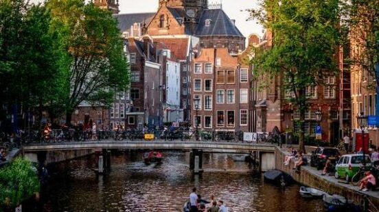 Cruise along the waterways of Amsterdam in a come evening