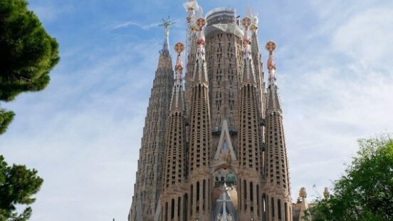 Gaudíx27;s organic spires of the Sagrada Família rising above Barcelonax27;s tree canopy.