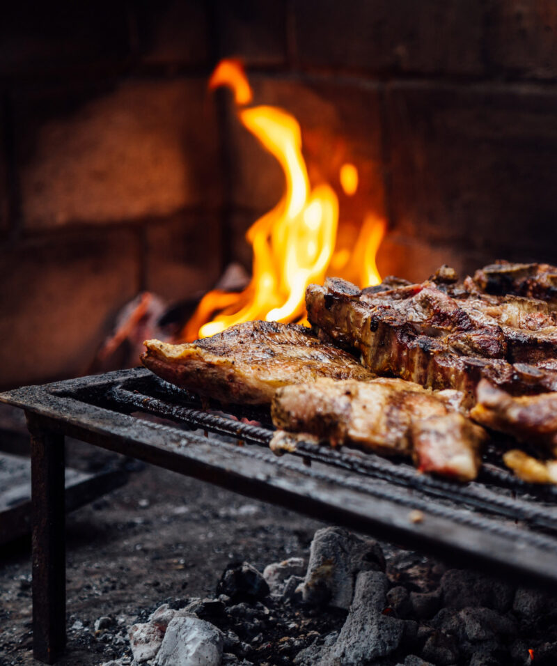 Barbeque, bbq meat cooking on grill. Traditional Asado of Argentina, Paraguay y Uruguay.