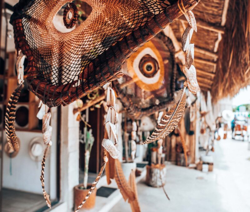 Handmade souvenir items made up of wooden and wicker on display for sale at a street shop in Tulum, Mexico