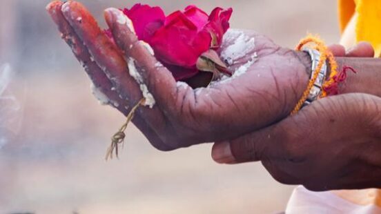 Varanasi, India - December 16, 2015 : Sacred flowers are taken for worship on hand at river Ganges
