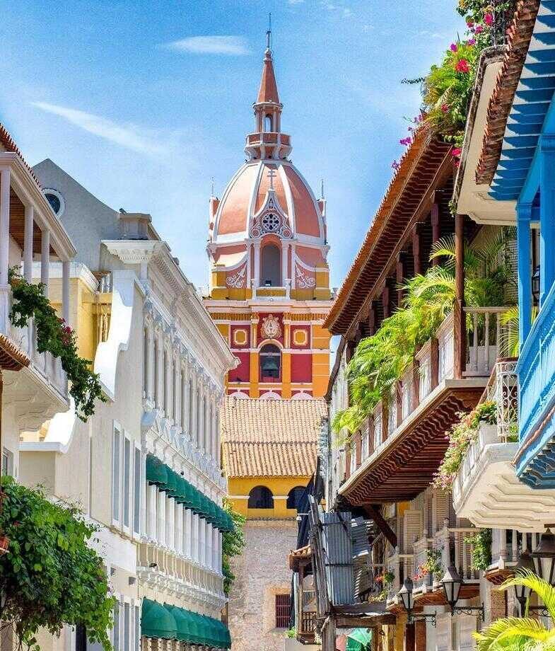 Blue skies are the backdrop for Colombiax27;s colourful building and a group of men deep in the valley of the Coffee Triangle