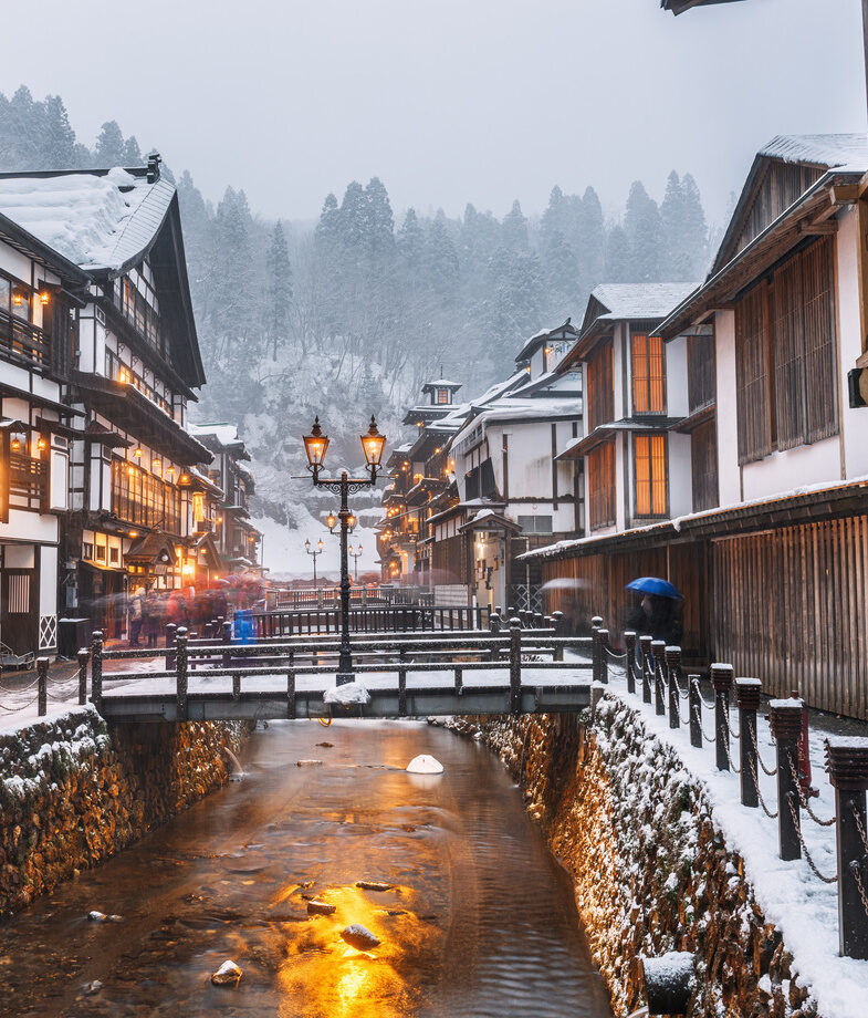 Snowfall over a traditional onsen town in Japan and a sunny stroll through the futuristic Supertree Grove in Singapore.