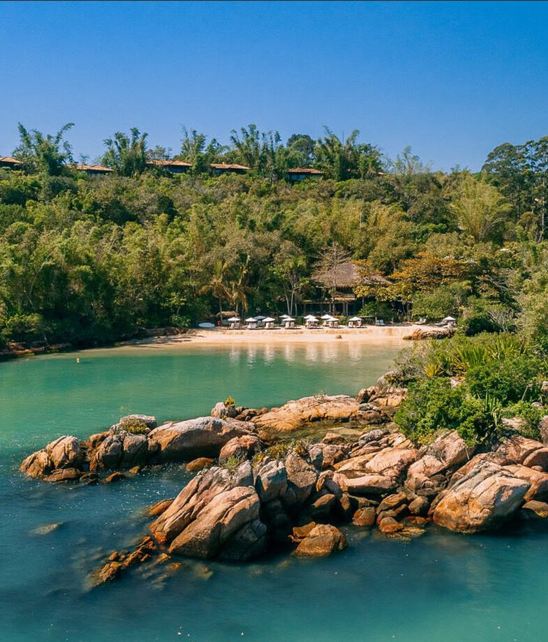 The clear waters of the private beach at Ponta Dos Ganchos and the rustic main lodge at Casa Caiman.