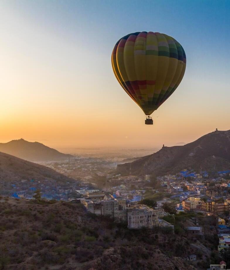 Looking out over Jaipur’s hillside fortresses and the ancient temple complex of Angkor Wat with a balloon drifting above.