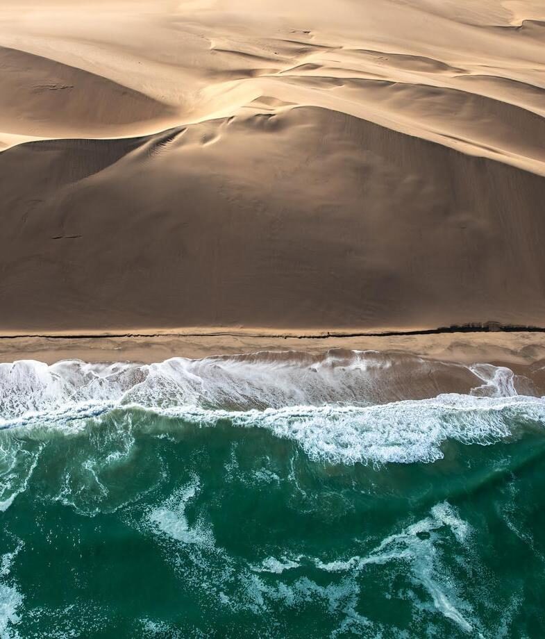An aerial view of the Skeleton Coast, showcasing its towering dunes, and whale watching in Walvis Bay, both on Namibia’s Atlantic coast.