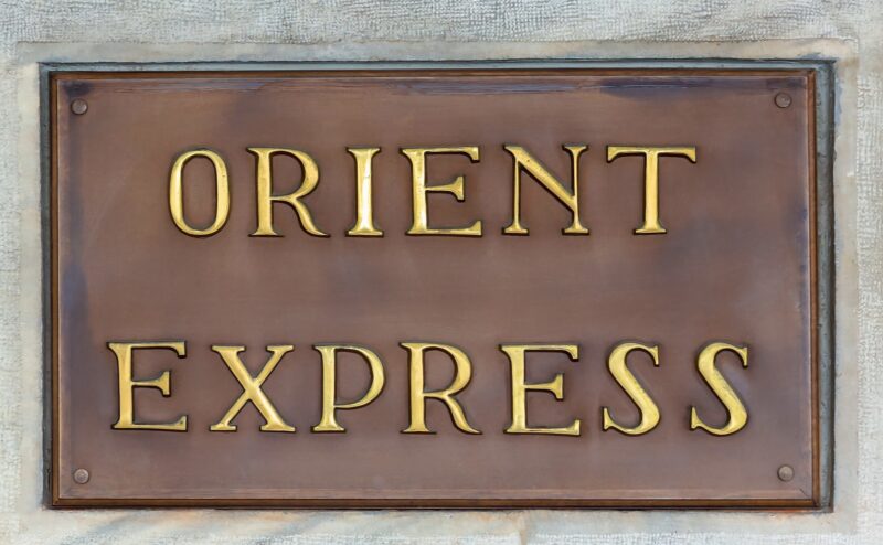 A bronze plaque with the words 'ORIENT EXPRESS' embossed in gold, symbolizing a high-end experience in luxury Europe rail tours.