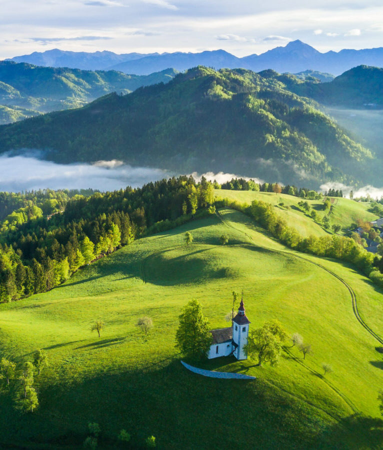Aerial view of Slonevian hills with a church on the hilltop