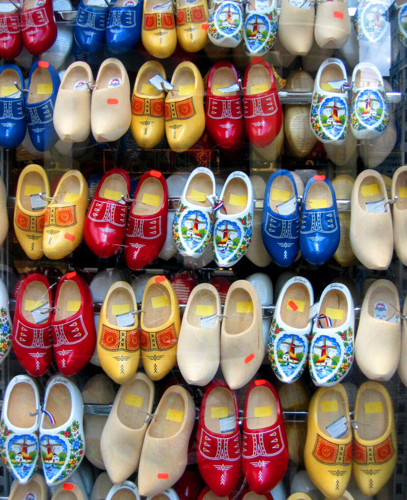 Rows of hand-painted Dutch clogs display bright traditional motifs on a boutique shop wall.