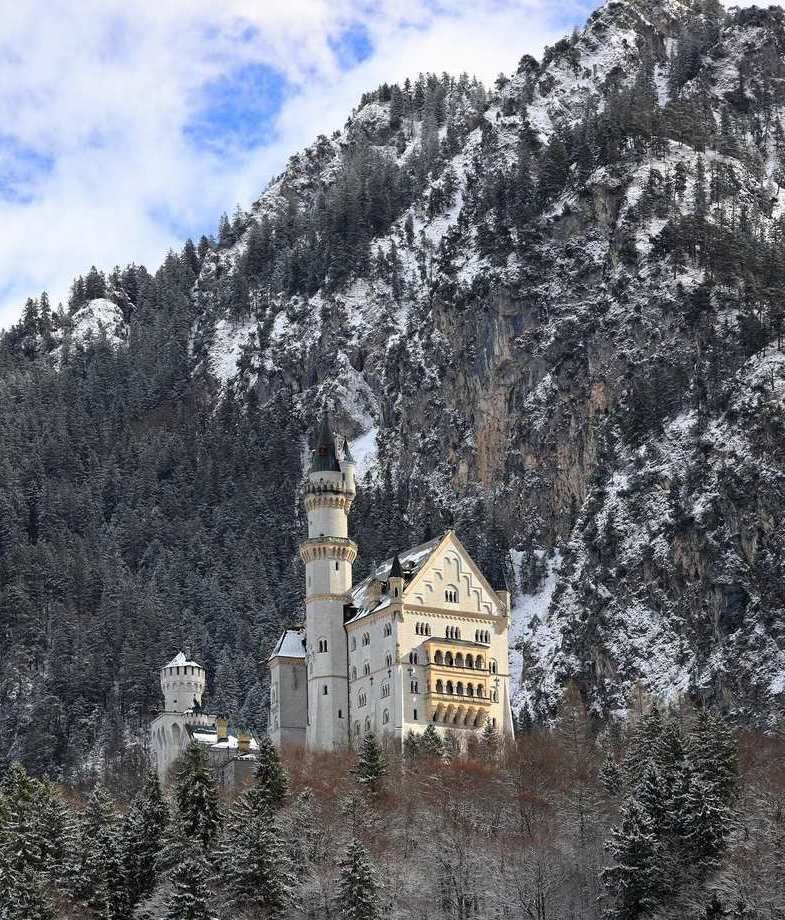 The glowing northern lights shimmering over Iceland’s frozen lakes and the snow-covered Neuschwanstein Castle nestled in Bavaria’s Alps, Germany.