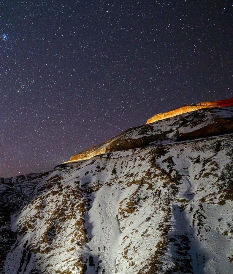 The snow-covered town of St. Moritz in Switzerland and the star-filled skies above the High Atlas Mountains in Morocco.