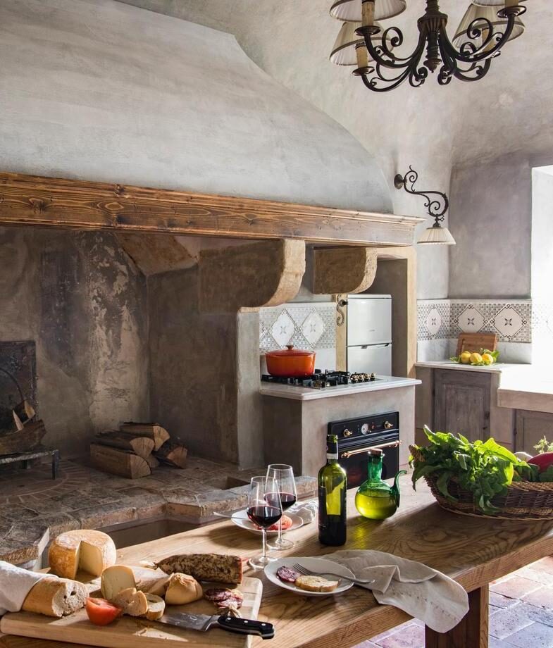 The rustic timbered façade of Les Sources de Caudalie in France, and the stone kitchen of Borgo Pignano in Italy capturing the essence of slow, organic dining.