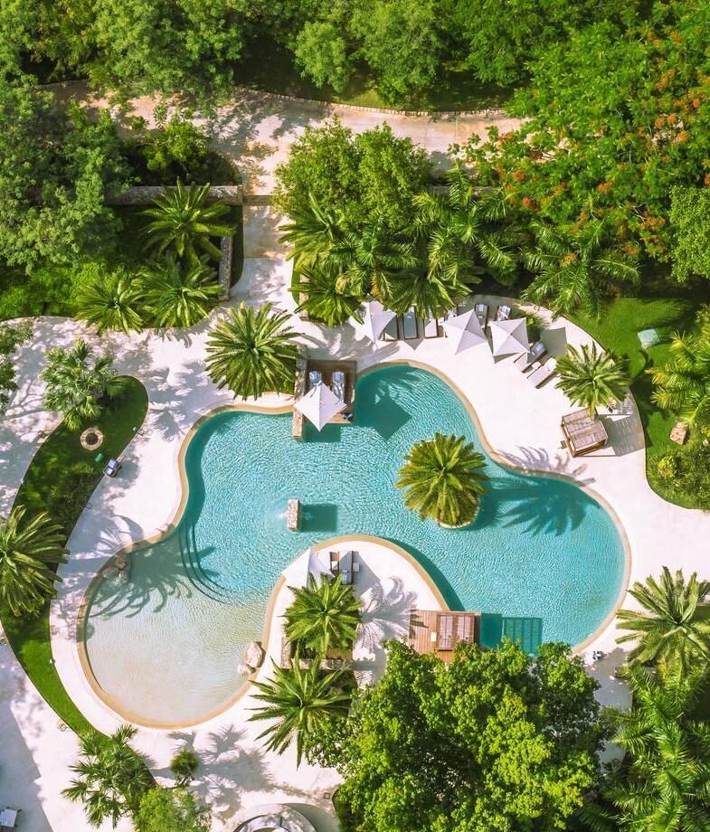 The glass-fronted terrace of El Silencio Lodge & Spa surrounded by the characteristic misty cloud forest of Costa Rica, and the swimming pool of Chablé Resort in Mexico on a sunny day.