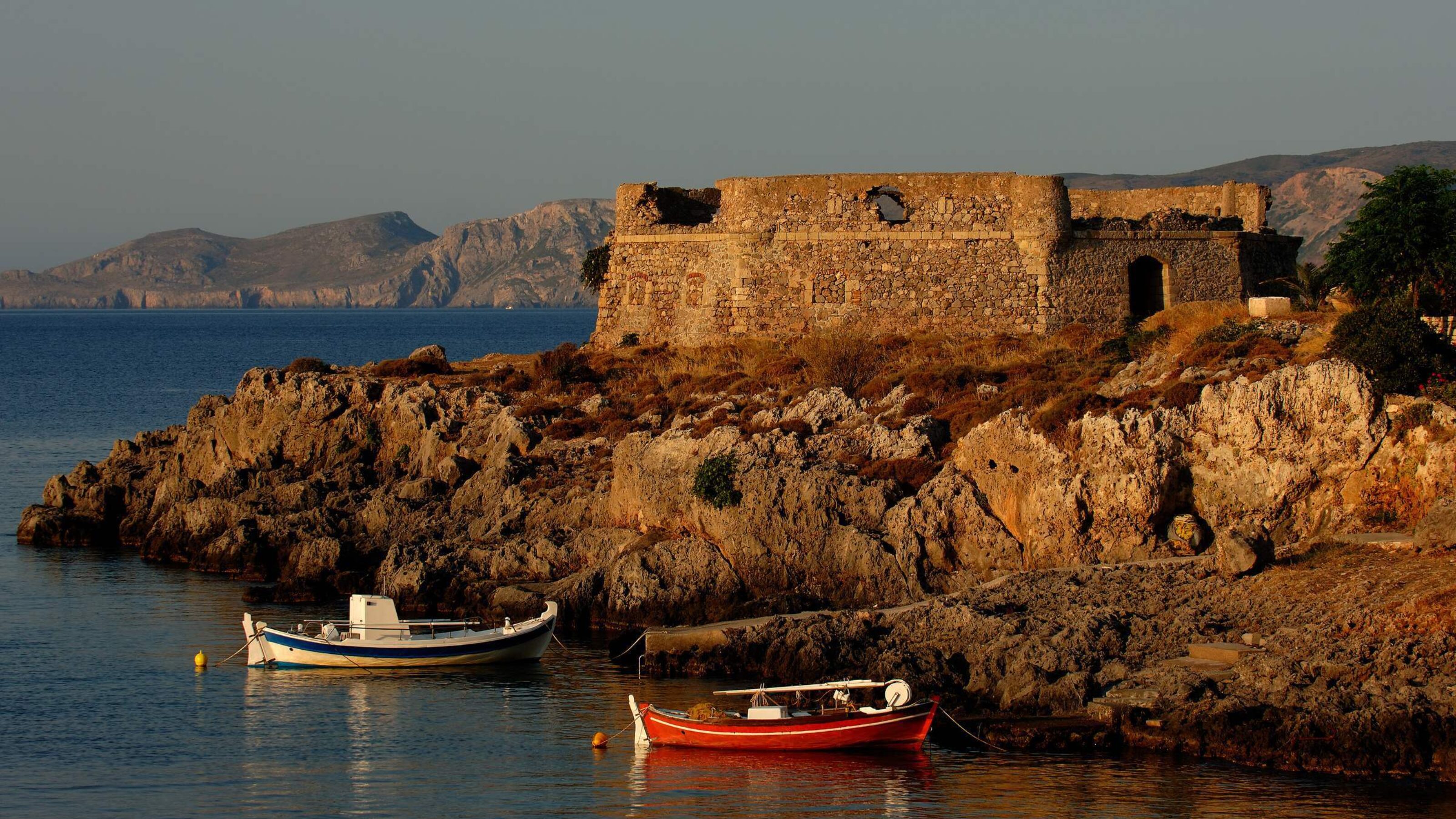 Fishing boats tied up at the edge of the water on the island of Kythera in Greece