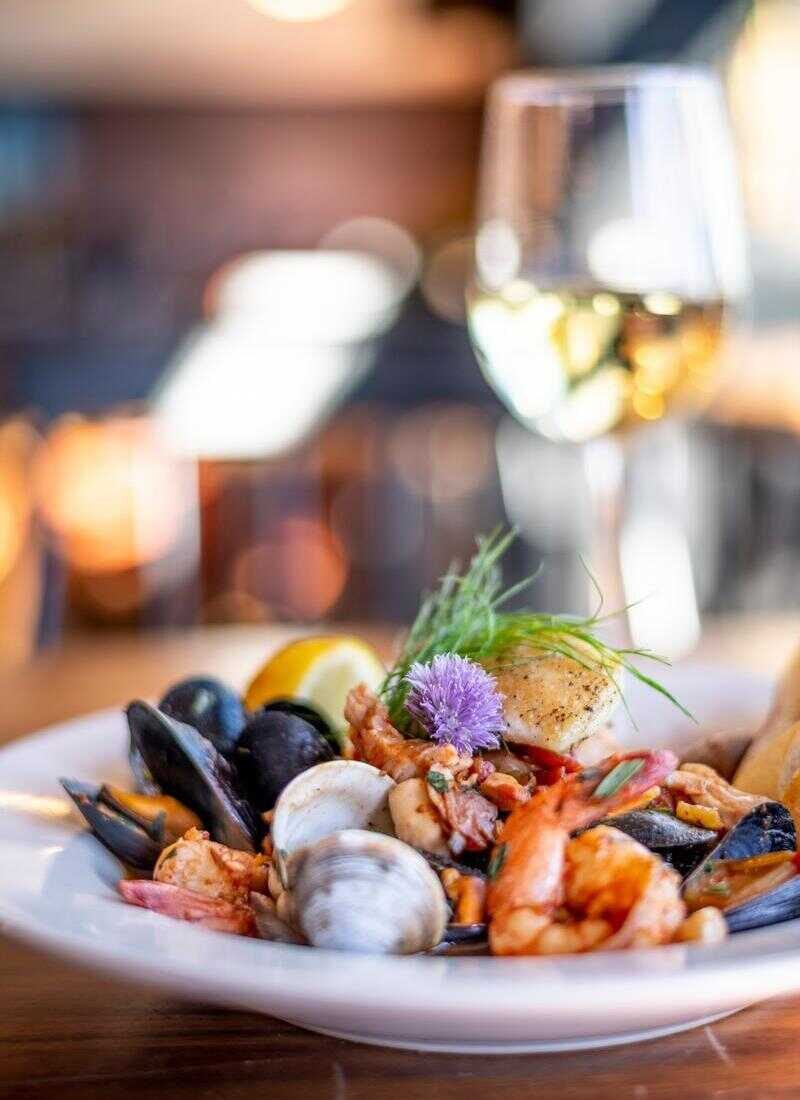 Bouillabaisse seafood stew with a glass of white wine