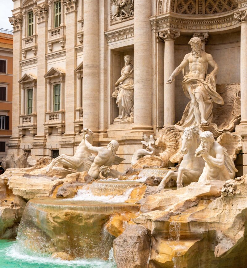 Travertine statues and rushing water frame Oceanus at the Trevi Fountain in Rome.