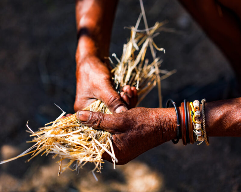 Working hands in Africa naturally make fire with straw