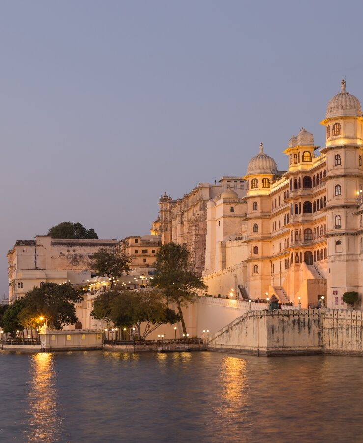 Udaipur City Palace from lake at sunset. India