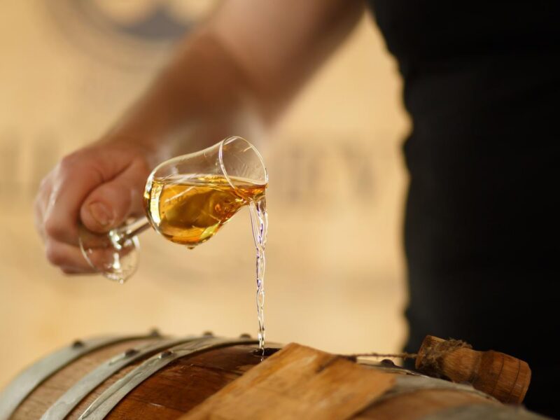 pour whiskey in barrels