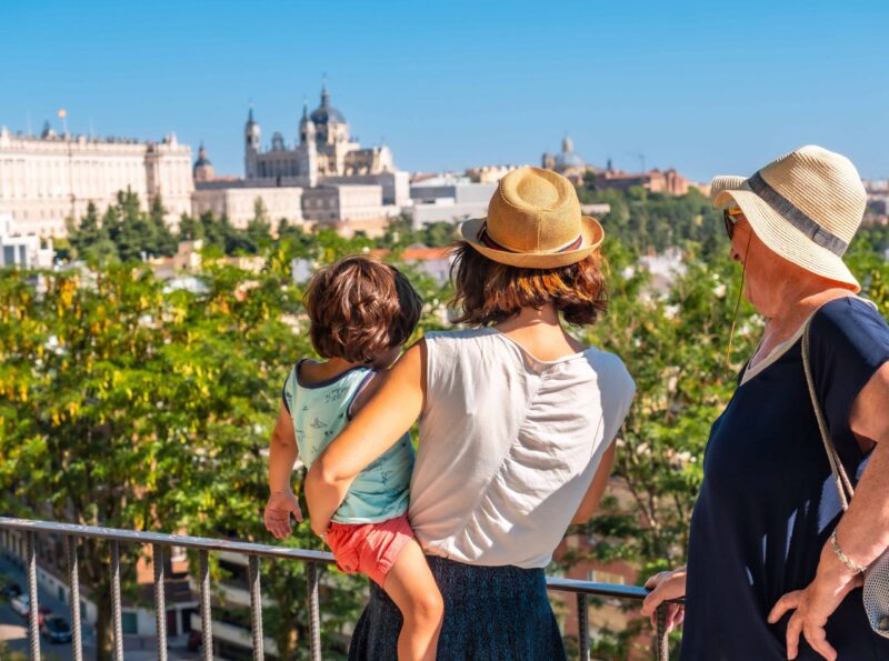 A family looking at the Cathedral of Santa Maria la Real de la Almudena and Royal Palace in the capital Madrid of Spain
