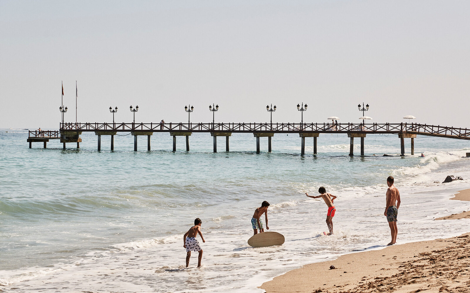 A family enjoying time together on the sandy shore at Marbella Club Hotel in Spain.