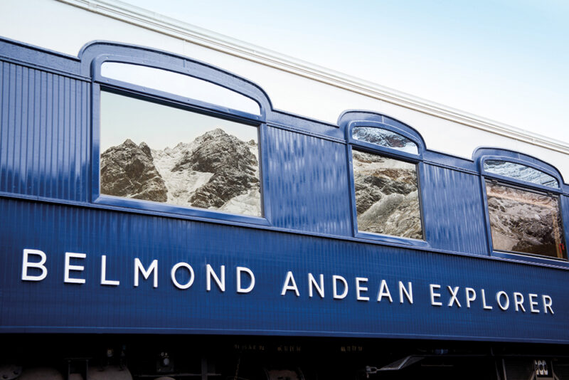 Mountain reflections on the blue exterior of luxury Peru train trips.