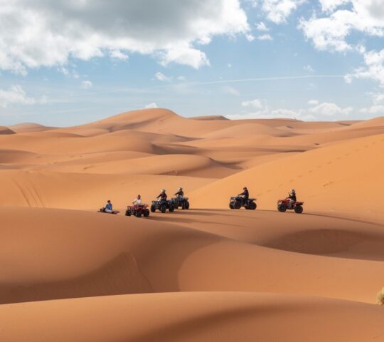 Race across sand dunes by buggy or ATV