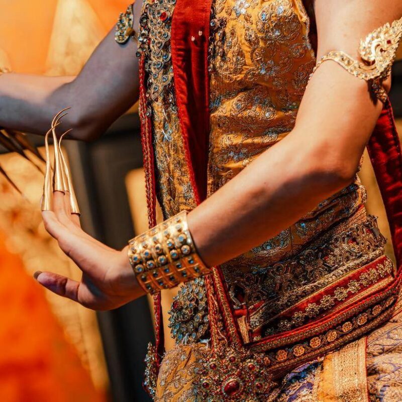 A traditional Thai dancer with a close up of the clothing and accessories.