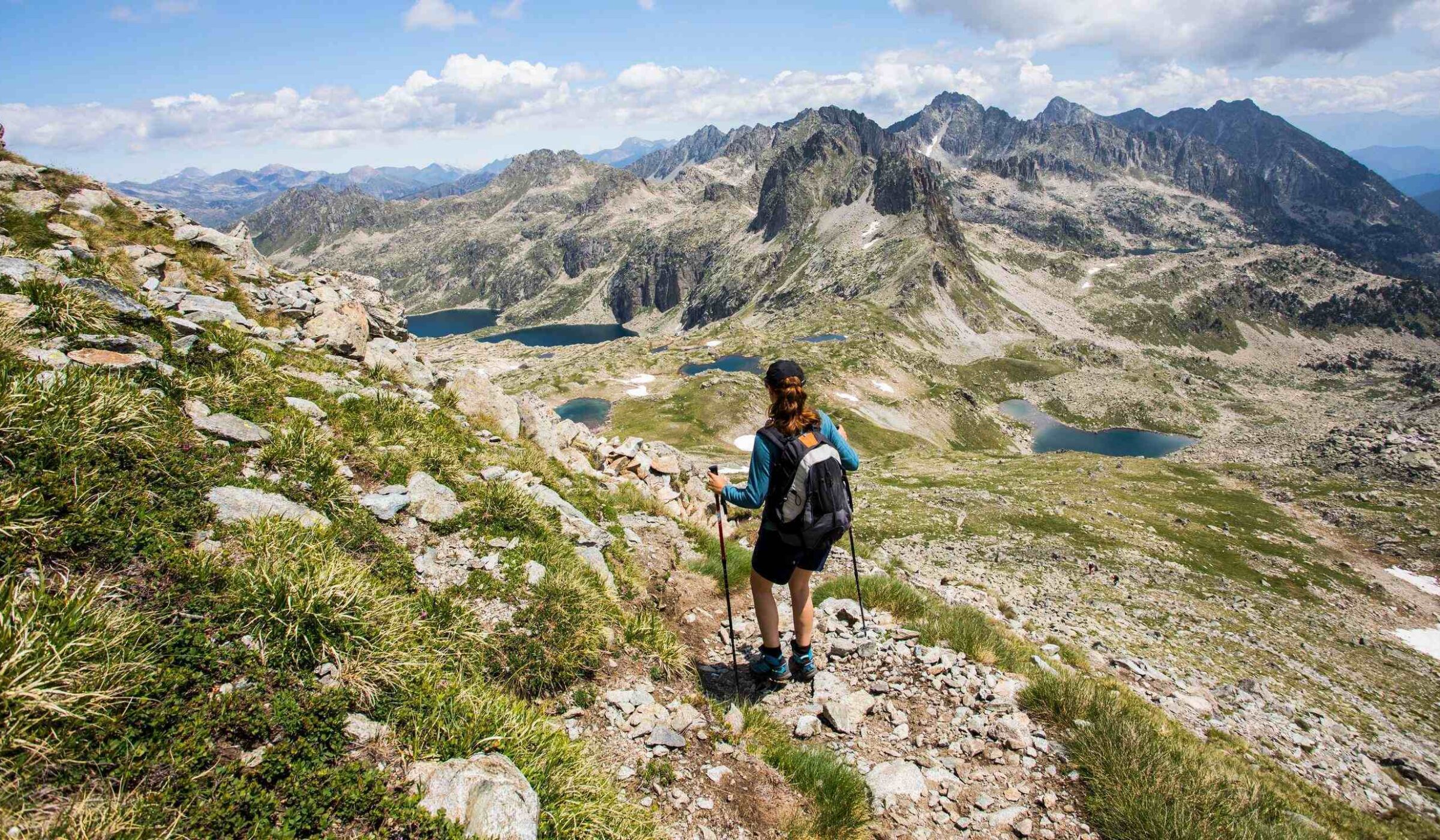 A woman hiking across mountainous landscapes in Sant Maurici National Park, Spain