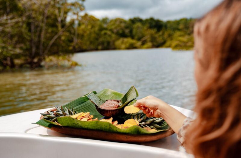 Person taking a chip from a wooden tray with dip on a boat during active costa rica.