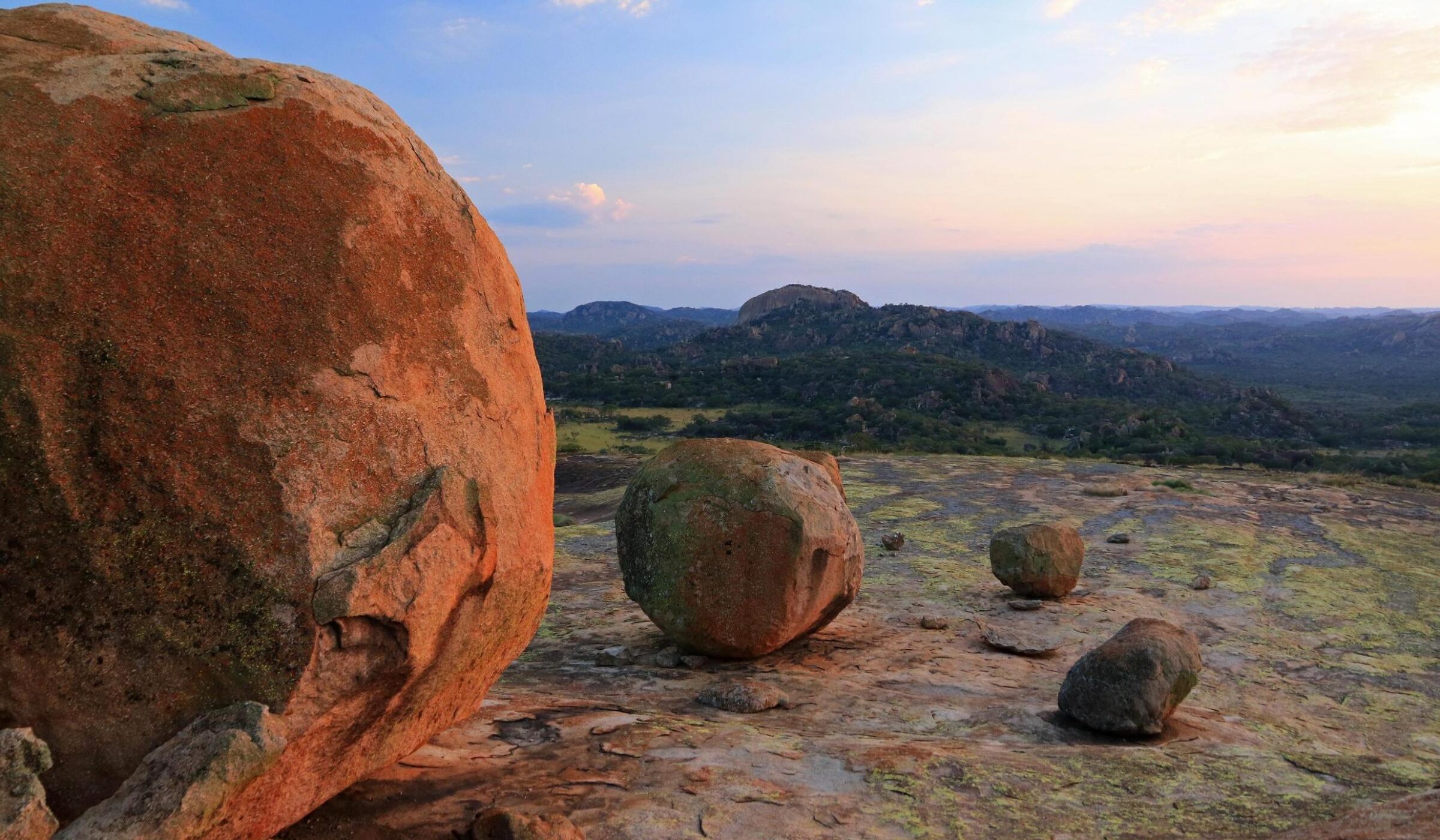 Large boulders on a rocky outcrop at Cecil Rhodes grave, Matobo National Park, Zimbabwe, with hills in the background.