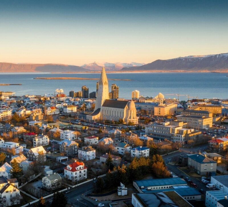 Aerial view of Reykjavik showing Hallgrimskirkja, colourful buildings, and mountains on a polar safari.